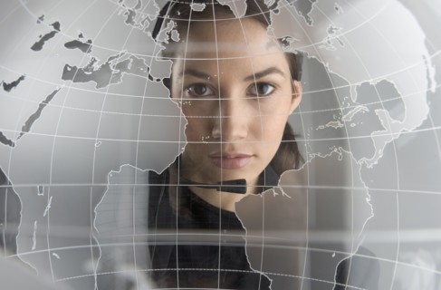 Portrait of woman looking through glass globe