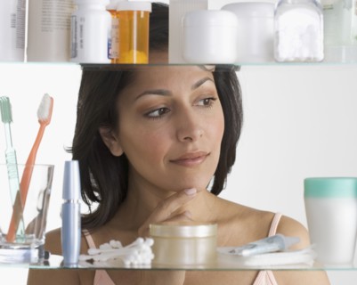 Young woman examining medicine cabinet