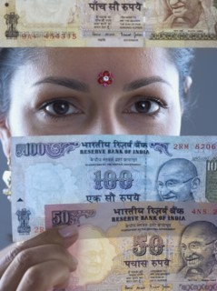 Woman in traditional Indian dress holding Indian money