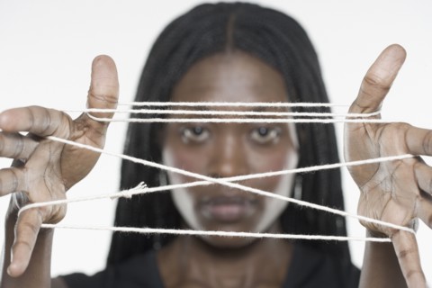 Young woman holding a cat's cradle out to the camera