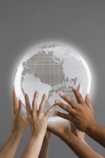 Close up of group of hands holding globe