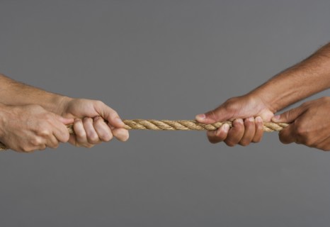 Close up of tug-o-war with four hands