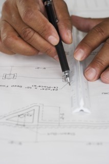 Close up of hands drawing plans with ruler