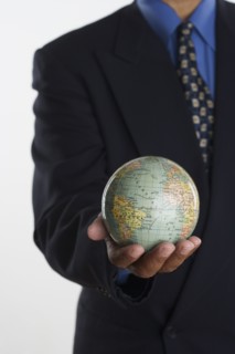 Mid section of businessman holding globe in hand