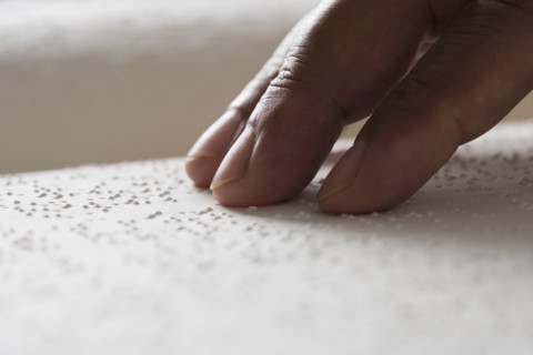 Close up of hand reading Braille
