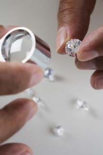 Close up of hands examining diamonds
