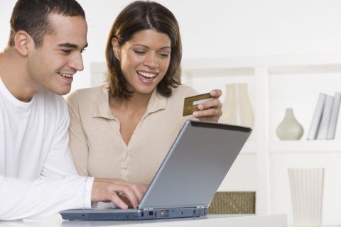 Couple ordering online with credit card and laptop