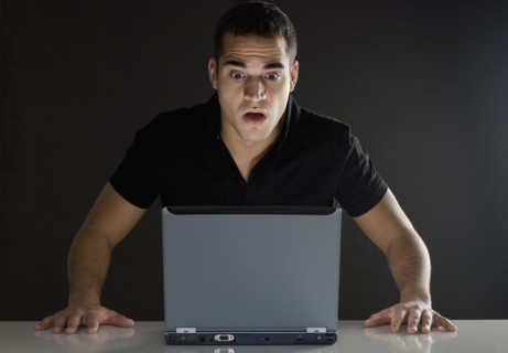 Man surprised while looking at laptop