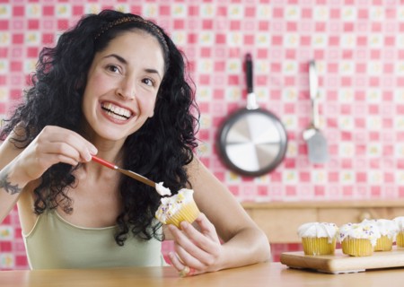 Young woman frosting cupcakes