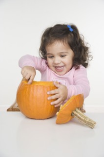 Little girl carving pumpkin