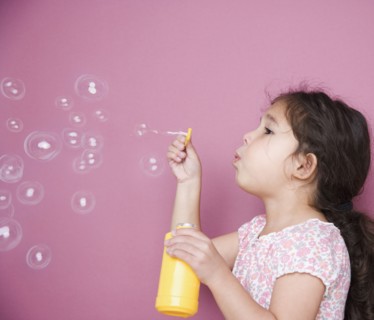 Girl blowing bubbles with wand