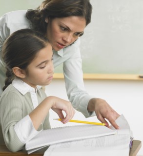 Teacher helping young student with work
