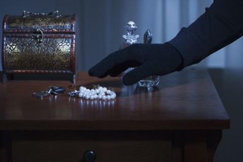Thief reaching for a string of pearls