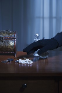 Thief reaching for a string of pearls