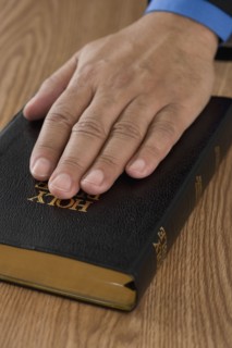 Close up of male hand on bible