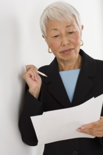 Senior Asian businesswoman reading paperwork