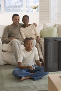 African family watching television in livingroom