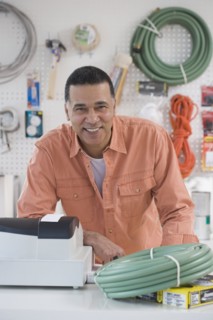 African hardware store owner smiling behind counter