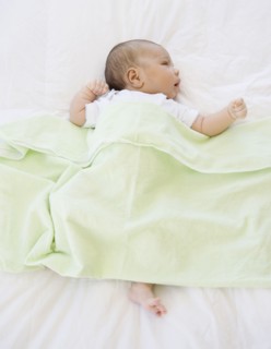 High angle view of newborn baby under blanket