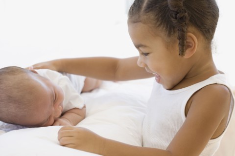 African girl smiling at baby sibling