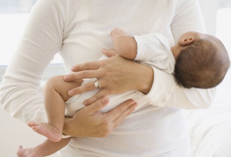 Close up of mother holding newborn baby