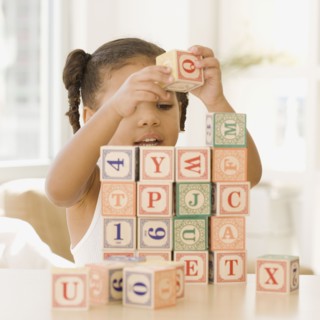 African girl building wall of blocks