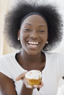 African woman holding cupcake