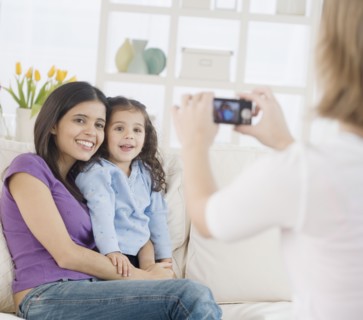 Hispanic mother and daughter having photograph taken