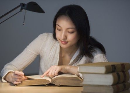 Asian woman reading at desk