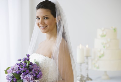 Hispanic bride holding bouquet of flowers