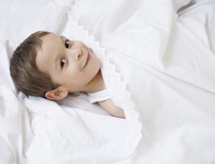 Hispanic boy laying in bed