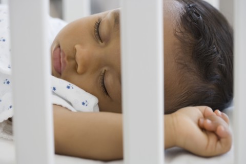 African American baby sleeping in crib