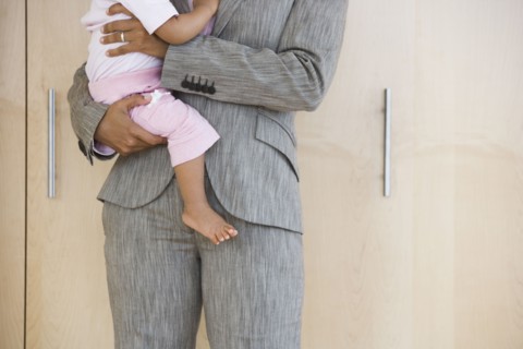 African American businesswoman holding baby