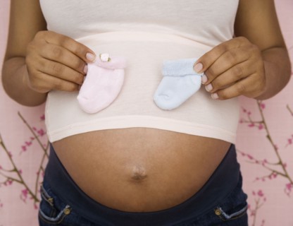 Pregnant African American woman holding booties