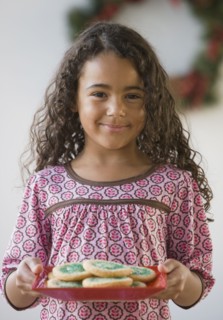 African girl holding plate of cookies