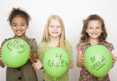 Multi-ethnic girls holding green balloons