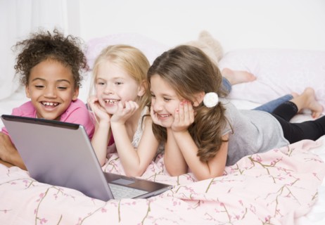 Multi-ethnic girls looking at laptop