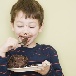 Hispanic boy eating cake