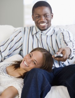 African couple watching television