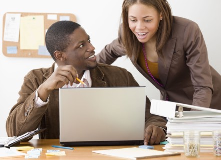 African businesspeople looking at laptop