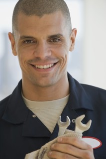Hispanic male mechanic holding wrenches
