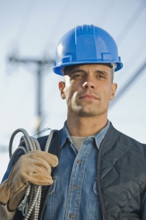 Hispanic male electrician carrying coiled wire