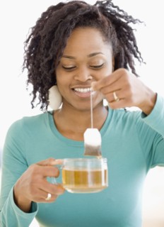 African woman holding tea bag