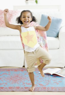 Mixed race girl pretending to be superhero