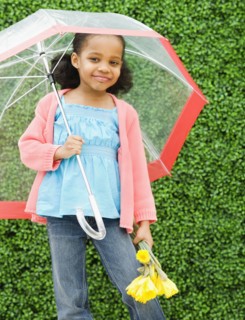 Mixed race girl with umbrella and flowers