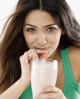 Middle Eastern woman drinking smoothie