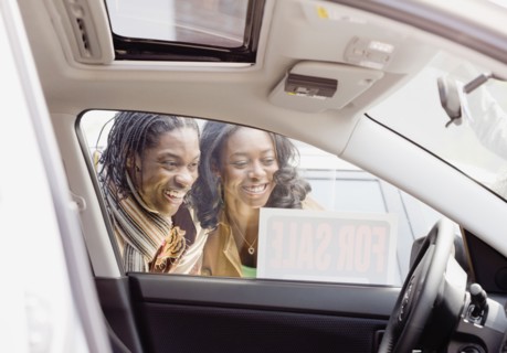 African couple looking at car for sale
