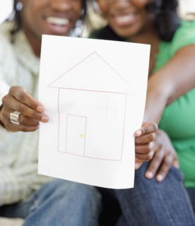 African couple holding drawing of house