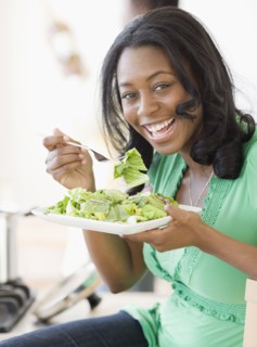 African woman eating salad