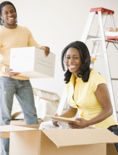 African couple packing moving boxes
